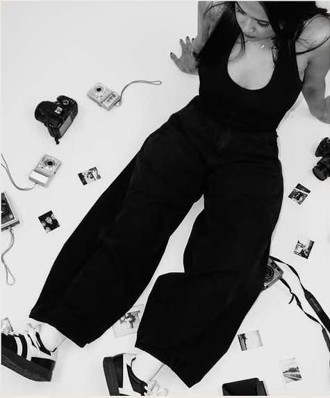 Nadine surrounded by cameras and printed photographs